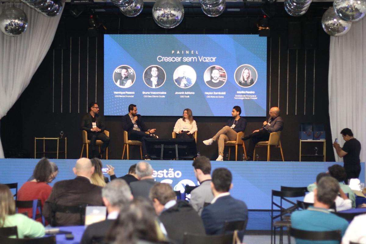 Painel de debate no palco com telão em evento de empresa no Innovare, em BH